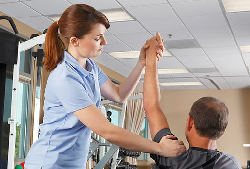 Female physical therapist stretching a patient's shoulder