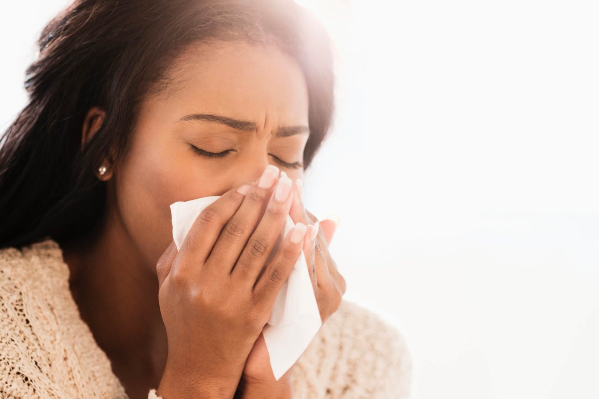 Woman blowing her nose.